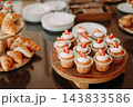 Strawberry cupcakes with whipped cream on a dessert buffet with fresh croissants 143833586