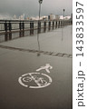 Worn pedestrian and bicycle lane markings on a wet urban pavement after rain 143833597