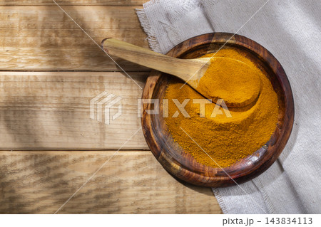 Turmeric powder in bowl on the table, top view 143834113