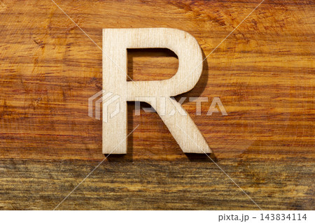 Wooden letters R on wooden background, top view Wooden letters R on wooden background, top view 143834114