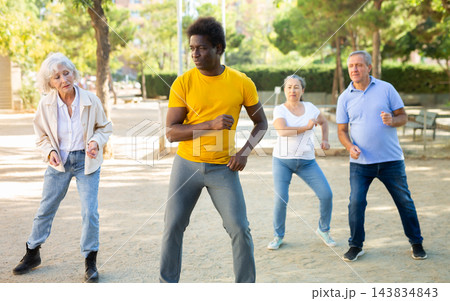 Active mature women and men learning modern dynamic dances in summer park 143834843