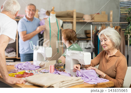 Mature women sew and talking, other senior student work with mannequin 143835065