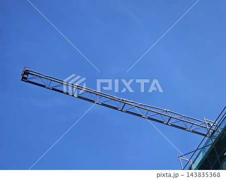 Long Steel Tower Crane Jib Extending Across Clear Blue Sky 143835368