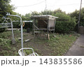 豊かな緑と雑草が広がる庭先に建つ、手作りの素朴な鶏小屋の風景 143835586