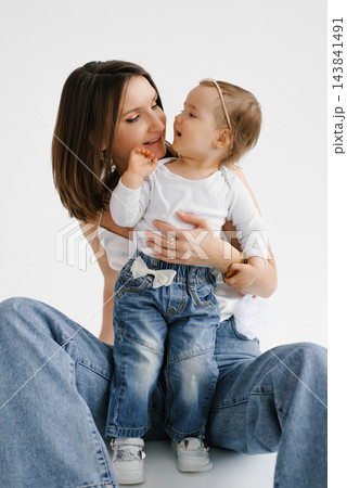 Mother Holding Toddler Daughter While Looking at Her Mother Holding Toddler Daughter While Looking at Her 143841491
