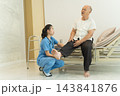Nurse assisting senior man with leg examination in clinic for healthcare. 143841876