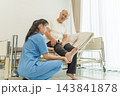 Nurse examining senior man's injured foot in hospital room for recovery support 143841878