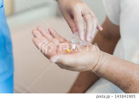 Healthcare professional dispensing medication to senior patient at clinic Healthcare professional dispensing medication to senior patient at clinic 143841905
