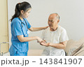 Nurse assisting senior man with medication in hospital for health care. 143841907