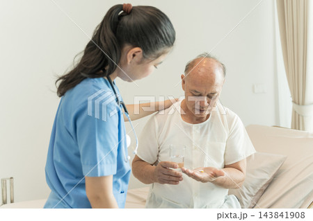 Nurse assisting elderly patient with medication in home care setting. Nurse assisting elderly patient with medication in home care setting. 143841908