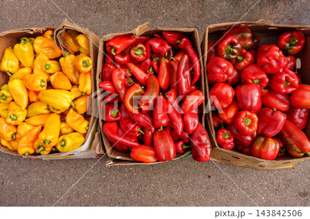 Red, yellow bell peppers in boxes at autumn market. Winter food stock preparation, farm products, harvest storage concept Red, yellow bell peppers in boxes at autumn market. Winter food stock preparation, farm products, harvest storage concept 143842506