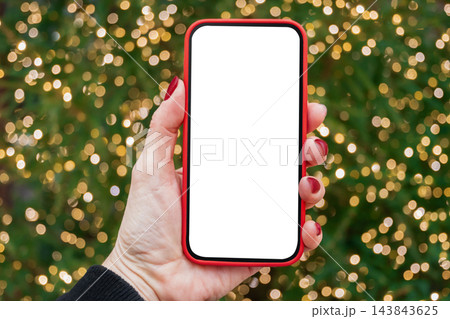 Smartphone with white blank screen against Christmas lights bokeh 143843625