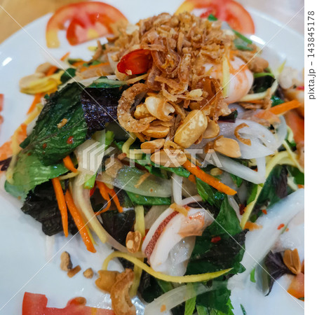 Fresh vietnamese salad with seafood, greens, carrots, and fried shallots 143845178