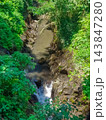 Aerial view of tropical jungle river gorge with small waterfall flowing through dense rainforest vegetation 143847280