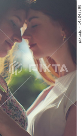 Vertical video. Two young lesbian women Embracing each other in park. Lifestyle and relationships. LGBT concept. Vertical video. Two young lesbian women Embracing each other in park. Lifestyle and relationships. LGBT concept. 143848299