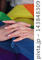 Vertical video. Close up lesbian couple in love holding hands on rainbow flag. Lgbt family holding hands outside. Woman relationship, lgbt family concept. 143848309