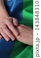 Vertical video. Close up lesbian couple in love holding hands on rainbow flag. Lgbt family holding hands outside. Woman relationship, lgbt family concept. 143848310