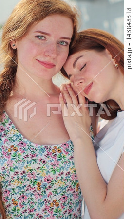 Vertical video. Lesbian couple closeup spending romantic time together standing on street. Vertical video. Lesbian couple closeup spending romantic time together standing on street. 143848318
