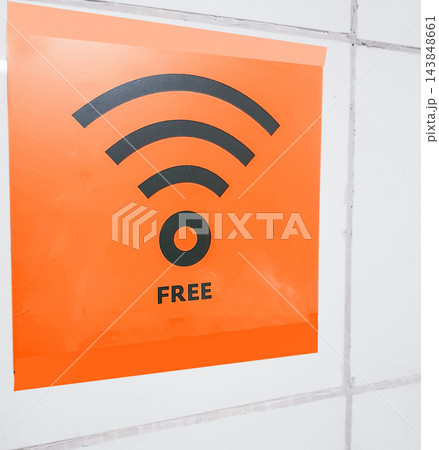 Free Wi-Fi zone symbol, orange sign on a white wall in a public empty space 143848661