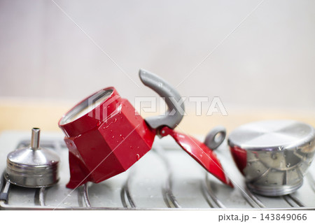 Red moka pot drying after washing on dish rack 143849066