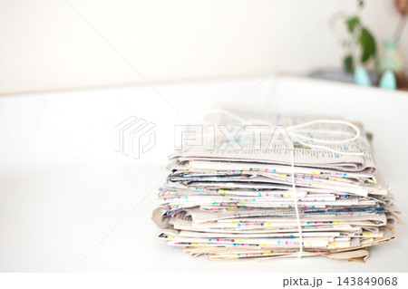 Stacked newspapers tied with string ready for recycling 143849068
