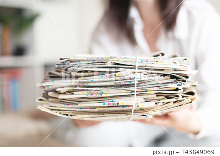 Person holding stack of old newspapers for recycling Person holding stack of old newspapers for recycling 143849069