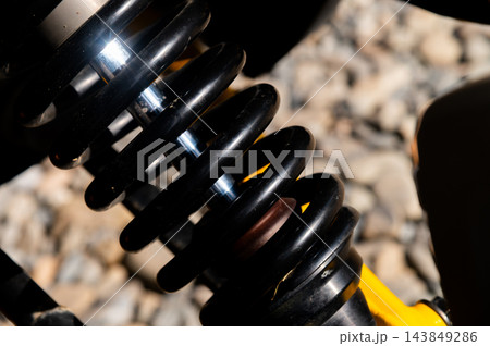 Close up of black vehicle shock absorber and spring Close up of black vehicle shock absorber and spring 143849286
