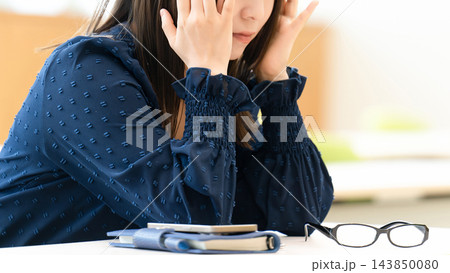 頭を押さえて悩む女性・頭痛・眼精疲労 頭を押さえて悩む女性・頭痛・眼精疲労 143850080