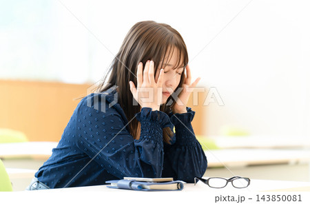 頭を押さえて悩む女性・頭痛・眼精疲労 頭を押さえて悩む女性・頭痛・眼精疲労 143850081