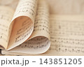 Heart shaped page fold in vintage sheet music book. Close-up selective focus photograph of vintage sheet music book pages folded into heart shape, symbolizing love for music, romantic melody 143851205