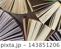 Abstract background of open vintage book pages forming fan patterns. Flat lay top view of multiple open hardcover books with fan-shaped fanned paper pages, abstract geometric texture pattern 143851206