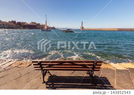 Empty Seaside Bench Overlooking Venetian Lighthouse and Harbor in Chania Crete Greece Empty Seaside Bench Overlooking Venetian Lighthouse and Harbor in Chania Crete Greece 143852543