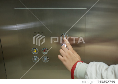 A blind woman presses a button with Braille in an elevator. A blind woman presses a button with Braille in an elevator. 143852749