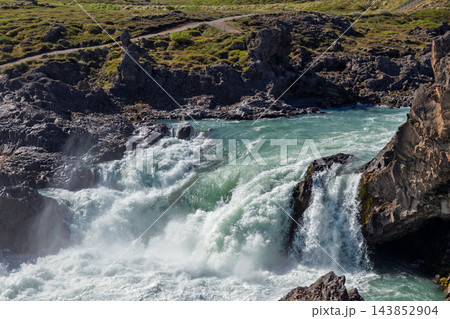 Turquoise river rapids surge through a rocky gorge below Godafoss, Iceland Turquoise river rapids surge through a rocky gorge below Godafoss, Iceland 143852904