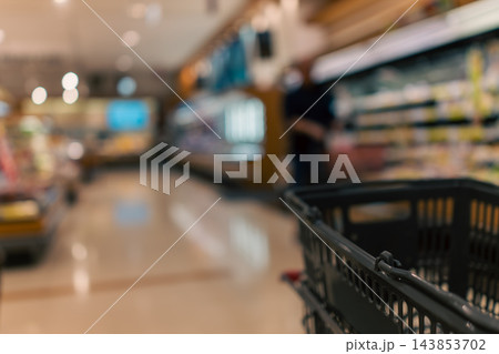 スーパーマーケットの店内とカートに載せた買い物かご スーパーマーケットの店内とカートに載せた買い物かご 143853702