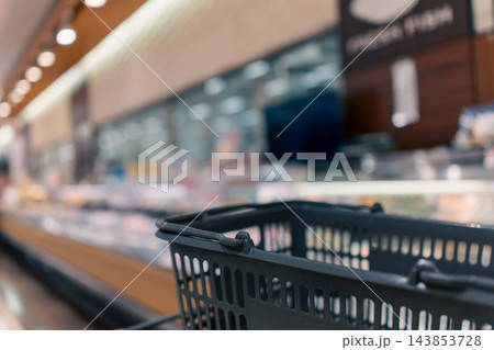 スーパーマーケットの店内とカートに載せた買い物かご スーパーマーケットの店内とカートに載せた買い物かご 143853728