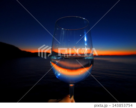 ワイングラス越しに見る沈む夕日 143853754