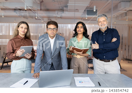 Portrait multiethnic team standing at office desk in conference room Portrait multiethnic team standing at office desk in conference room 143854742
