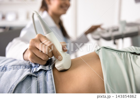 Hand of ultrasound diagnosing doctor examining patient Hand of ultrasound diagnosing doctor examining patient 143854862
