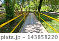 Outdoor Paved Bridge Path with Bright Yellow Metal Handrails in Park    143858220