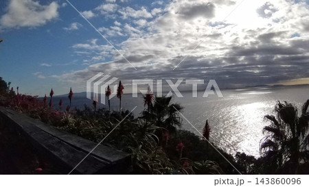 雲間から差し込む光が海面を照らす海岸風景 143860096