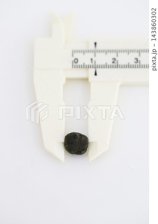 白バックで撮影した10mm程度の緑がかった黒い胆石 143860302