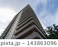 見上げるマンション 143863096