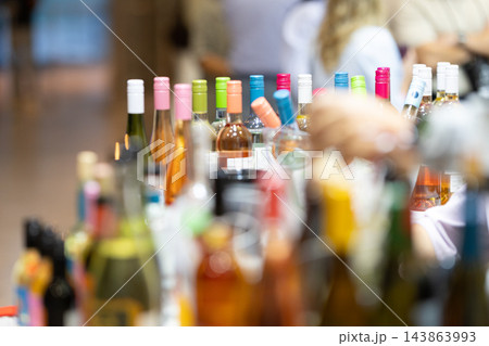 Wine bottles on display at an indoor tasting event during the day 143863993