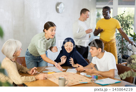Group of multinational people playing board game Group of multinational people playing board game 143864219