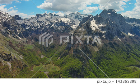 Rocky snow mountains and green valley aerial Rocky snow mountains and green valley aerial 143865899