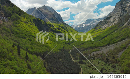 Rocky snow mountains and green valley aerial Rocky snow mountains and green valley aerial 143865913