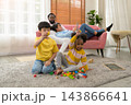 Multiracial family relaxing at home while children play with colorful building blocks on living room carpet at home 143866641