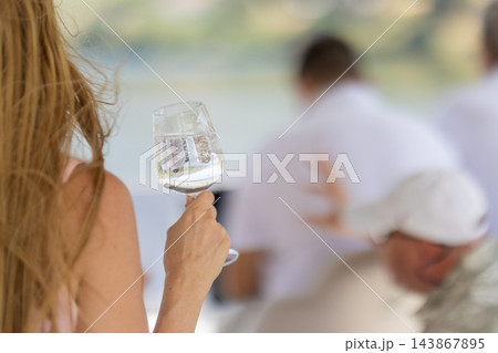 Woman holding a sparkling wine glass during outdoor dining Woman holding a sparkling wine glass during outdoor dining 143867895