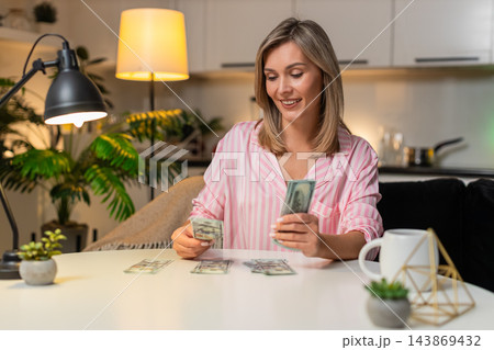 Adult woman counts cash dollars sorts budget piles expenses savings plans family finance night plan 143869432